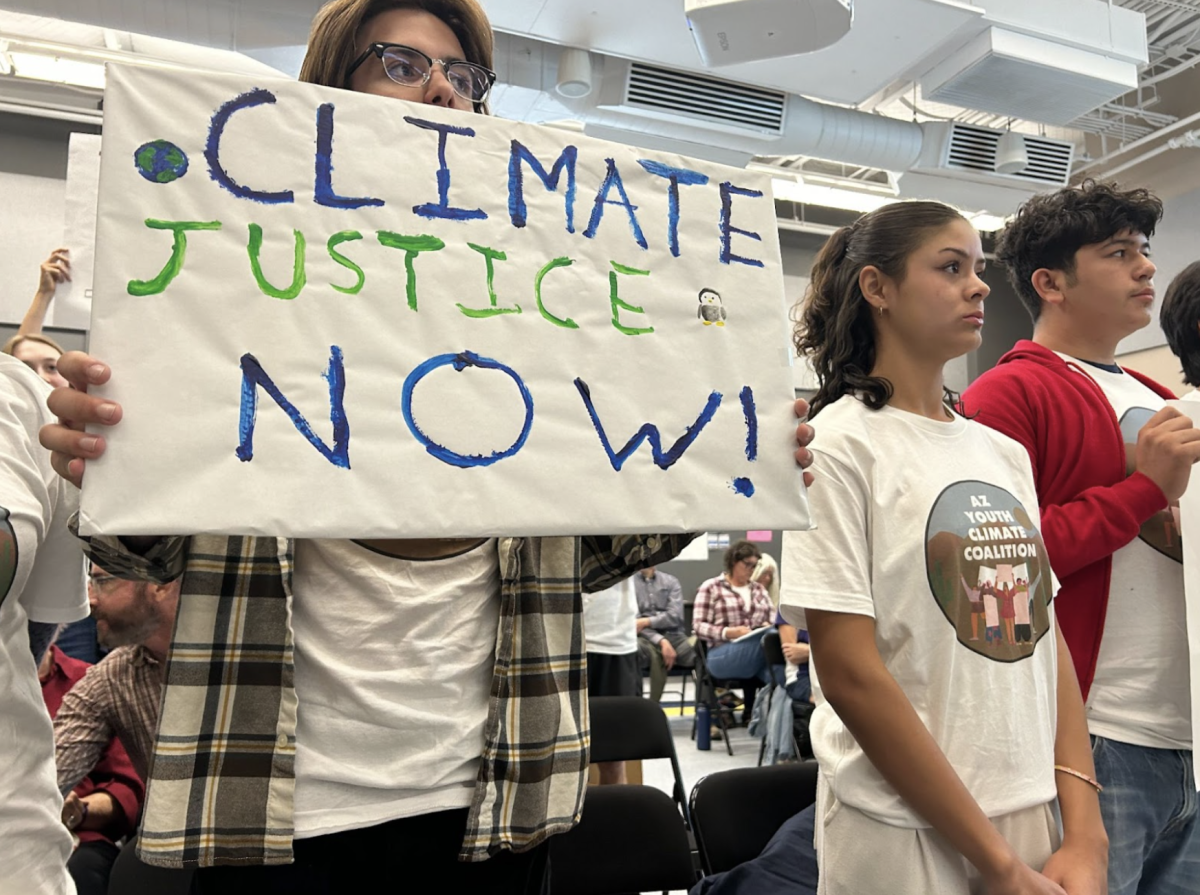 Member of the Arizona Youth Climate Coalition holds a sign that
reads “Climate Justice Now!” alongside other observers and students while
public commentary is made on the Climate Action Resolution. The Climate Action Resolution was passed on Oct. 29. 
